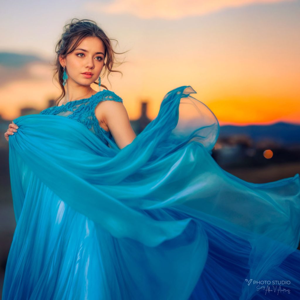 Fotografía de Quinceañera - Sesión de fotos de 15 años en Pamplona - Una niña de 15 años posa con su vestido de fiesta azul en un atardecer en un pueblo de Navarra